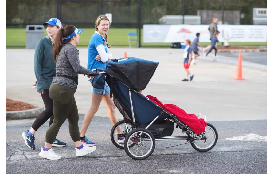 Caregiver pushing the Advance Mobility Freedom push chair outdoors